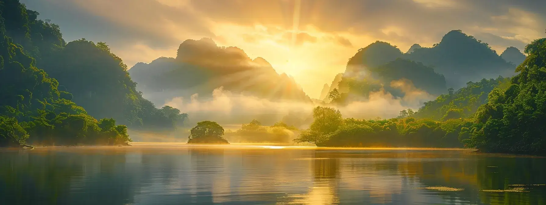 a breathtaking sunrise casts golden hues over a serene, mist-covered lake surrounded by towering, lush green mountains, embodying tranquility and the beauty of nature.